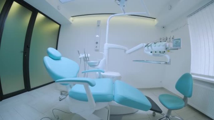现代牙科诊所。牙科用的椅子和其他配件由牙医在蓝色，军医灯。鱼眼