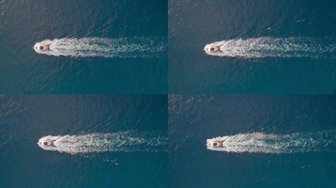 一艘船，一艘机动船在俯视图中使用雷达巡逻。摄像机跟随在水面上留下巨大印记的船。