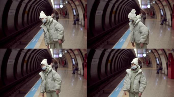 戴口罩的女孩在地铁里等火车