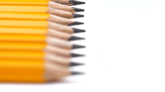 简单的灰色铅笔排成一排，移动的焦点放在尖杆尖上，准备书写。木头铅笔作为创意艺术绘画。选择性关注锋利的