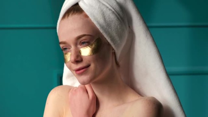 可爱的雀斑姜女人洗澡后戴着金色眼罩，肩膀空着