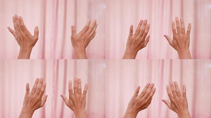 两只手举起，挥舞着告别或问候，孤立在粉红色背景上。手语。