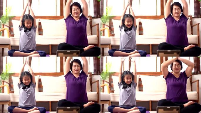亚洲母女在家做瑜伽带着幸福