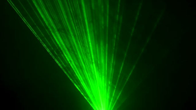 黑色工作室背景上的激光霓虹灯的动态绿色光束在烟雾中旋转。舞台全息图的展示。假日和派对的照明设备和效果