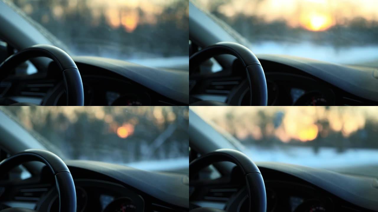 冬季驾驶汽车时，驾驶员的手握住方向盘，特写。在积雪湿滑的道路上驾驶理念，霜冻