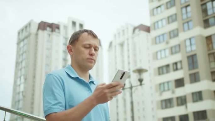 市民用手机冲浪，写短信，站在城市建筑的背景下