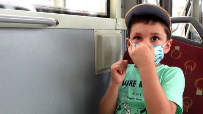 小男孩在公共汽车上戴着防护口罩