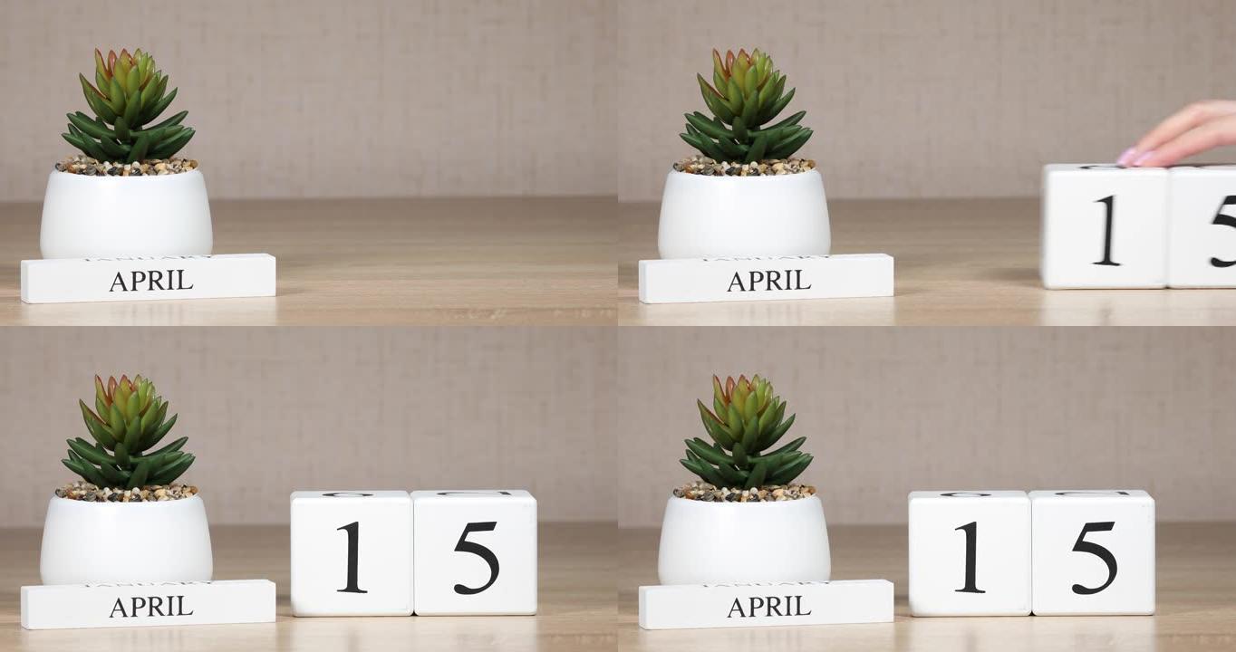 木制日历对4月15日来说是一个重要的事件，女人的手在日历上设置日期。春季。