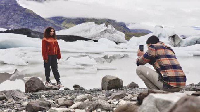 一名女性游客与背景冰川合影的照片