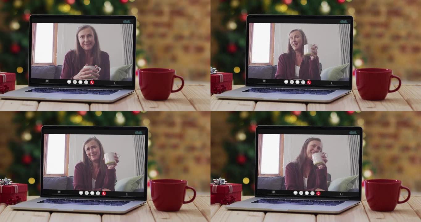 快乐的高加索高级妇女在笔记本电脑上进行视频通话，带有圣诞节装饰和树木