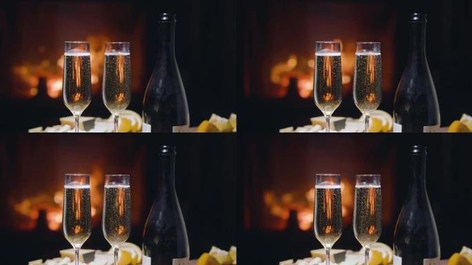 两杯香槟中的气泡慢慢向上上升。壁炉里的火在后面燃烧。浪漫晚餐。慢动作150fps，黑魔法Ursa P