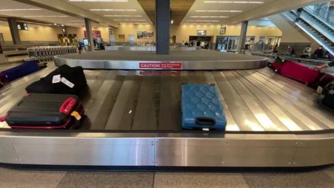 男子在机场的行李认领处从行李传送带上抓起行李