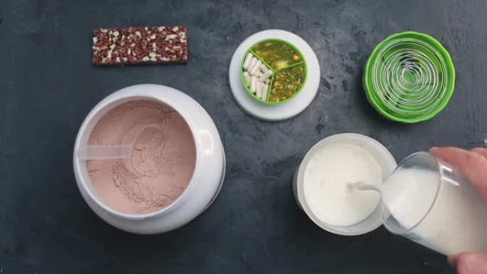 将牛奶倒入摇床，制作巧克力蛋白动力饮料的过程，慢动作，俯视图