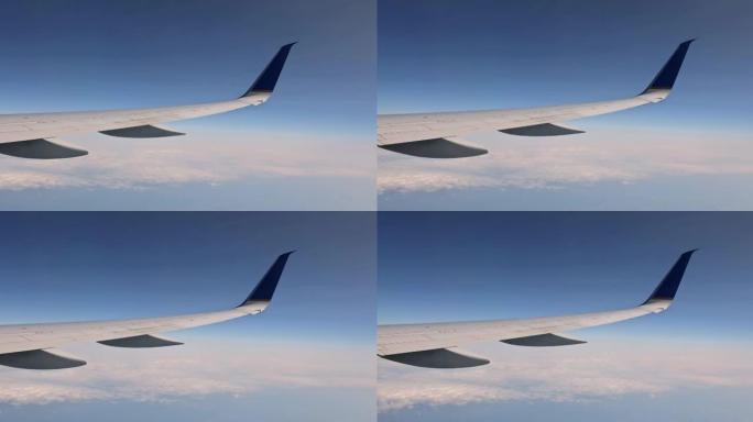 从窗户鸟瞰飞机机翼的云和天空