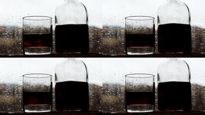 一杯威士忌和一瓶在靠近雨窗的酒吧里。水滴从玻璃上掉下来。酒吧里的酒精