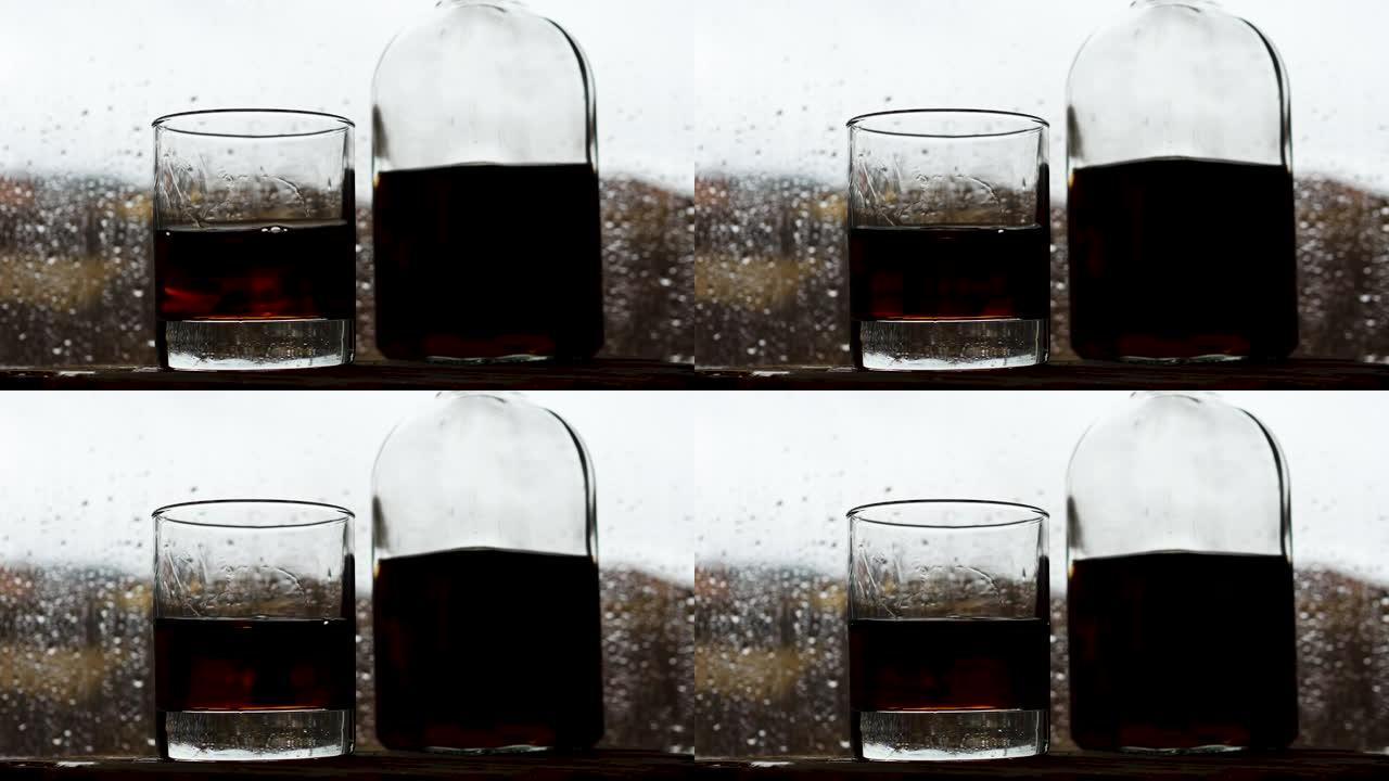 一杯威士忌和一瓶在靠近雨窗的酒吧里。水滴从玻璃上掉下来。酒吧里的酒精