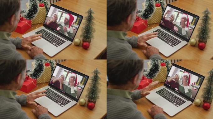 白人高级男子在屏幕上与儿子和孙子在笔记本电脑上进行圣诞节视频通话