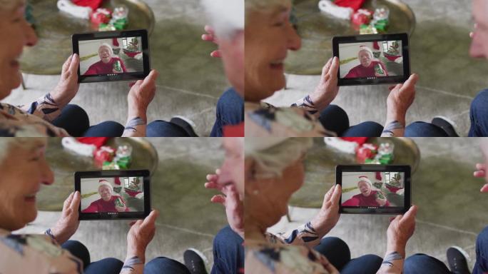 高级高加索夫妇使用平板电脑与屏幕上的快乐男人进行圣诞节视频通话