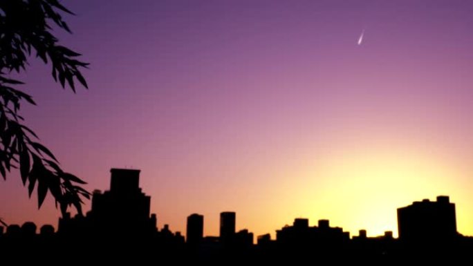 日落风景与城市的建筑轮廓。焦点在正面，背景模糊。镜头轻微晃动。天空的色温是紫色的。