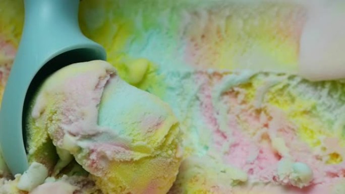 彩虹冰淇淋用蓝色勺子舀。