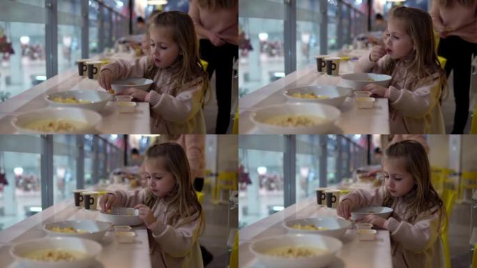 餐馆里的一个小女孩吃酱汁炸薯条。孩子在机构里吃饭。