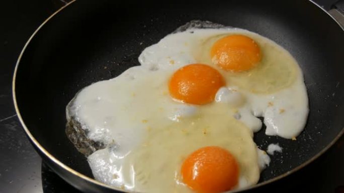 锅中撒上香料的煎蛋的特写镜头