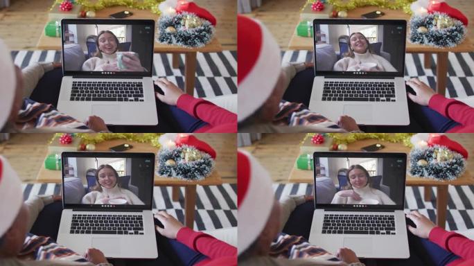 非裔美国母亲和女儿使用笔记本电脑与屏幕上的女人进行圣诞节视频通话