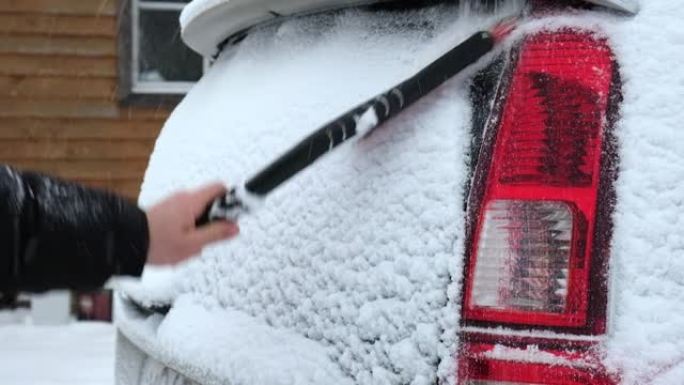 暴风雪暴风雪后，人从车窗上刷新鲜的雪。冬季寒冷天气车主的早晨常规困难。车窗清洁。冬季。白雪。车辆保养