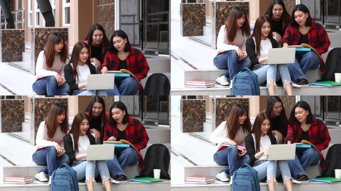 大学密友一起坐在楼下的教学楼上，以亲密的方式在书本和笔记本电脑上讨论教育和学习。青少年学生生活方式的