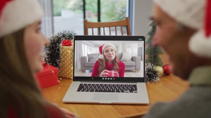 快乐的高加索高级夫妇在圣诞节与女性朋友进行视频通话