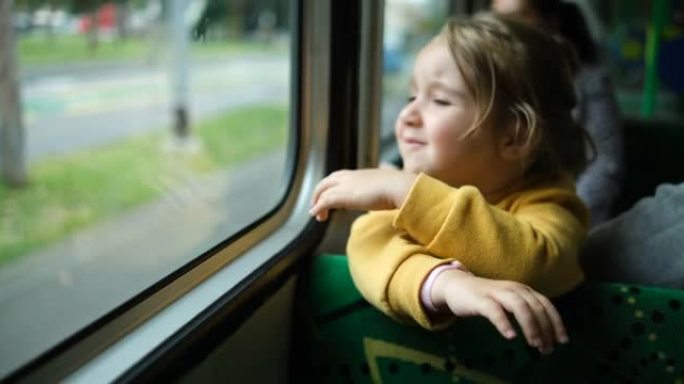 可爱的小女孩在电车上看着窗外的肖像