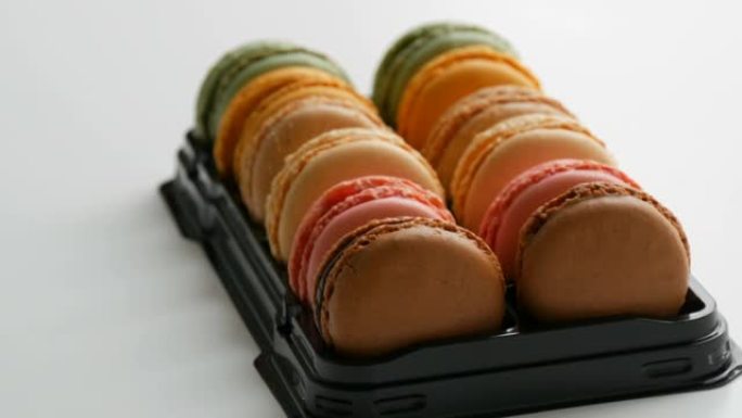 彩色法国饼干马卡龙或马卡龙放在白色桌子上的特殊黑匣子里