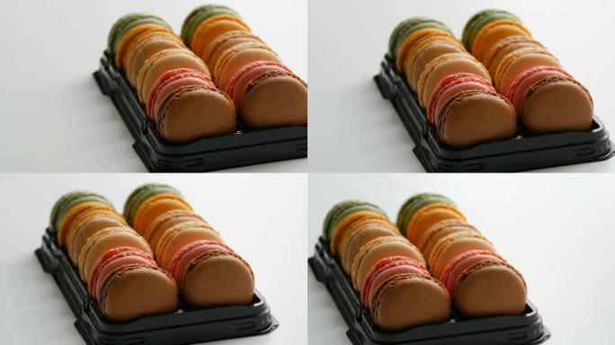 彩色法国饼干马卡龙或马卡龙放在白色桌子上的特殊黑匣子里