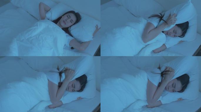 穿着睡衣的亚洲美丽沮丧的女孩在黑暗的夜晚睡在床上。迷人的年轻女子躺着，由于噪音而感到沮丧和愤怒，并在