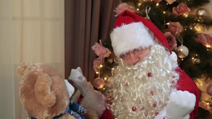 有趣的圣诞老人向泰迪熊展示技巧。