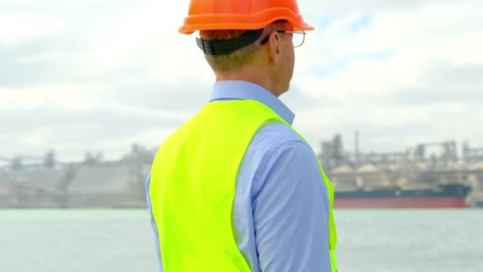 戴着眼镜的海运港口行业工程师看着粮仓