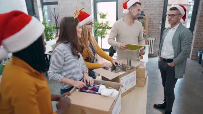 办公室里迷人的多种族同事，为圣诞节捐赠准备盒子