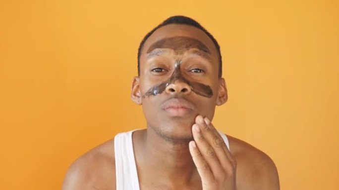 一名年轻的非洲裔男子的肖像在t区戴着黑色面具，人们想摆脱粉刺和黑头，孤立的背景