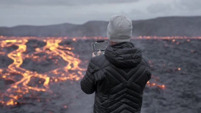 摄影师控制无人机并眺望熔岩场