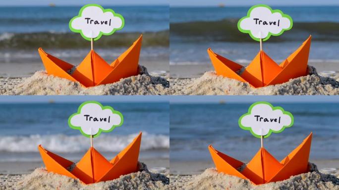 沙滩上的橙色纸船特写。阳光明媚的夏日，蓝色大海背景上的小船。坚持在船上插入文字旅行。概念旅游、度假、