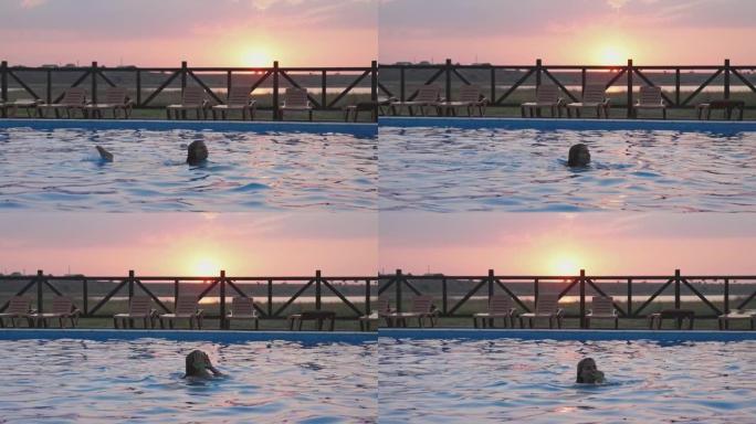 穿着彩色比基尼的湿头发的女孩在夏天日落的背景下从透明清水的游泳池里出来