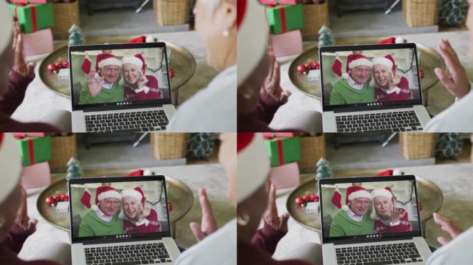 多元化的高级女性朋友使用笔记本电脑与屏幕上的幸福夫妇进行圣诞节视频通话