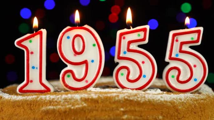 生日蛋糕与白色燃烧的蜡烛在数字1955的形式