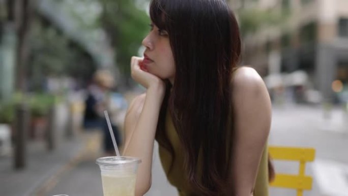 穿着黄色连衣裙的美女在户外咖啡馆放松