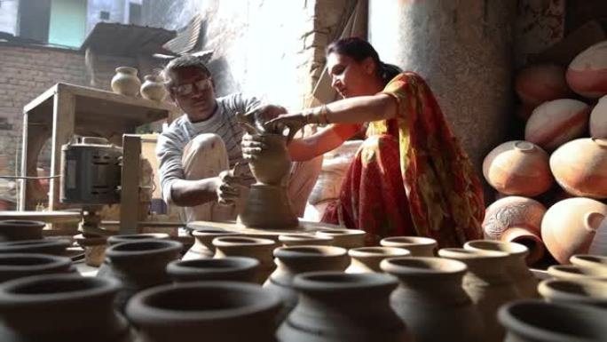 父亲和女儿在纺车上做陶罐。