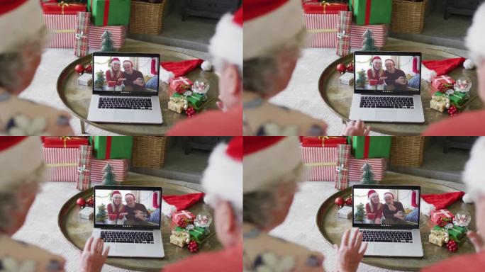 高级高加索夫妇使用笔记本电脑与屏幕上的幸福夫妇进行圣诞节视频通话