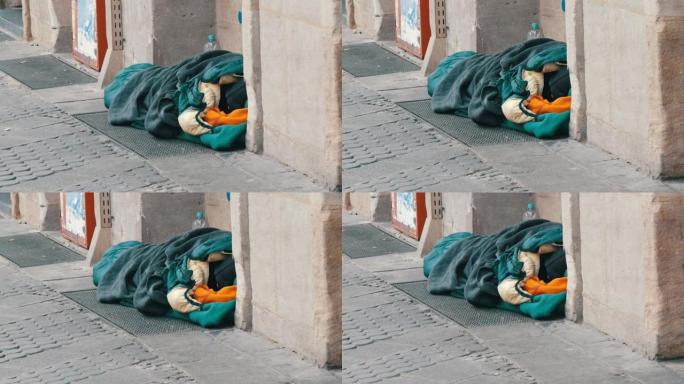德国纽伦堡-2019年12月10日: 一个无家可归的贫穷乞丐躺在地上，躺在睡袋里，冬天在城市街道上求