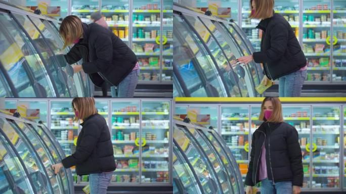 女人在超市购物，食品和消费品时戴着保护口罩。女孩打开冰箱。
