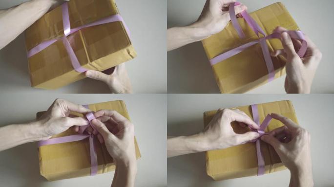 业余礼品包装纸在没有包装纸的纸板箱上做蝴蝶结。