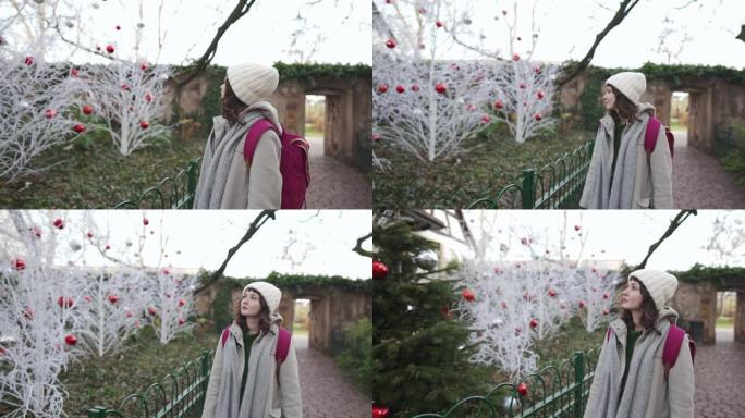 走在科尔马的女人在圣诞节期间用白树装饰